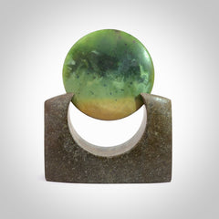 Hand carved New Zealand Flower Jade Disc with Greywacke stand sculpture. Hand carved here in New Zealand by Ric Moor. This is a 'one only' sculpture, a beautiful display piece. Small Jade disc sculpture for desk.