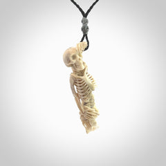 Hand carved deer antler, bone skeleton lying on its side pendant online for sale. Creative necklace for lovers of skeletons hand made from deer antler, bone. Free shipping worldwide. We provide this pendant with an adjustable cord.