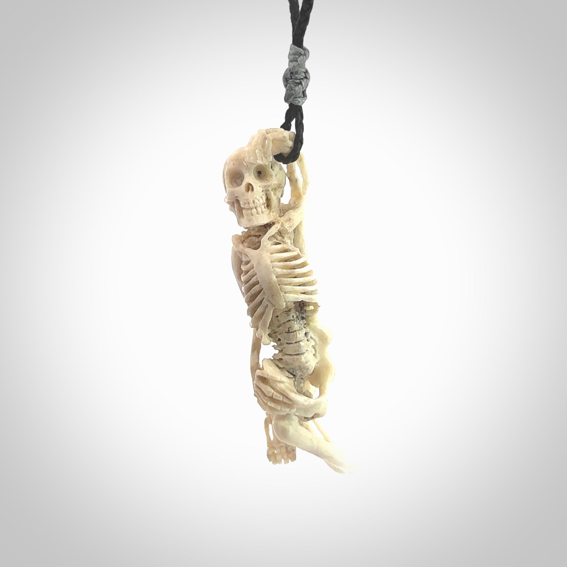 Hand carved deer antler, bone skeleton lying on its side pendant online for sale. Creative necklace for lovers of skeletons hand made from deer antler, bone. Free shipping worldwide. We provide this pendant with an adjustable cord.