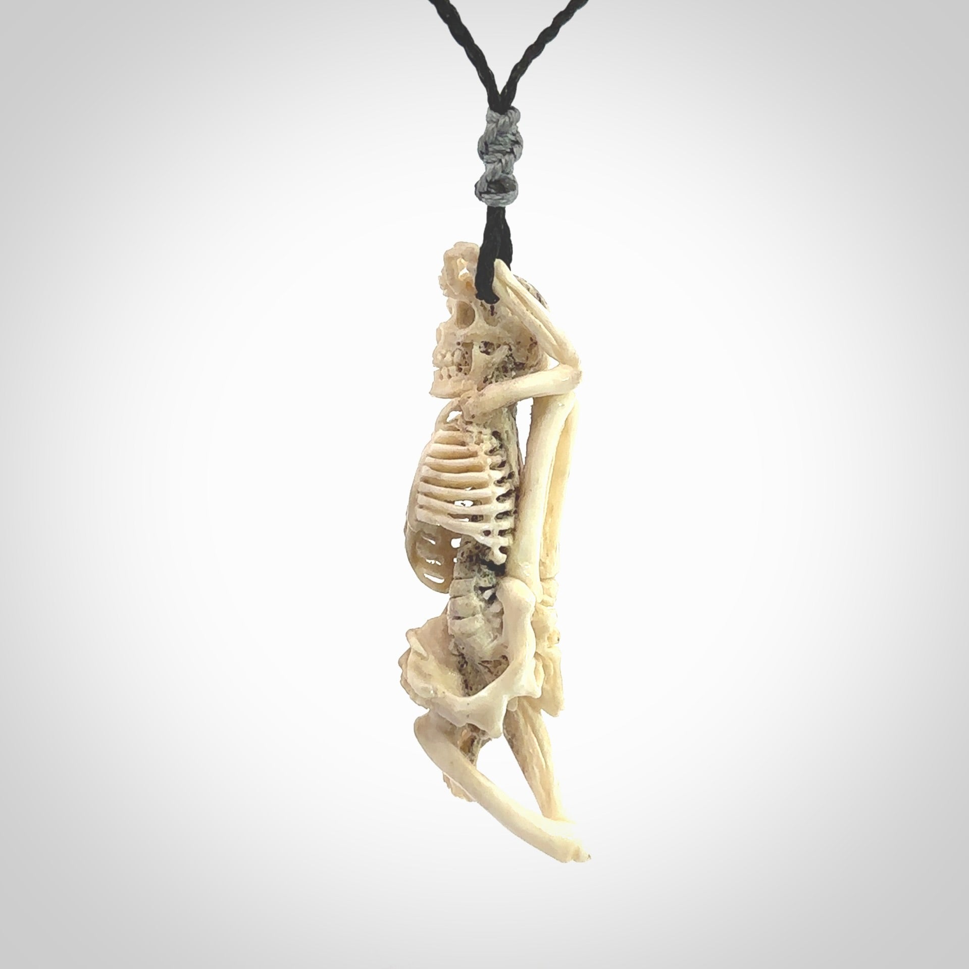 Hand carved deer antler, bone skeleton lying on its side pendant online for sale. Creative necklace for lovers of skeletons hand made from deer antler, bone. Free shipping worldwide. We provide this pendant with an adjustable cord.