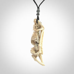 Hand carved deer antler, bone skeleton lying on its side pendant online for sale. Creative necklace for lovers of skeletons hand made from deer antler, bone. Free shipping worldwide. We provide this pendant with an adjustable cord.