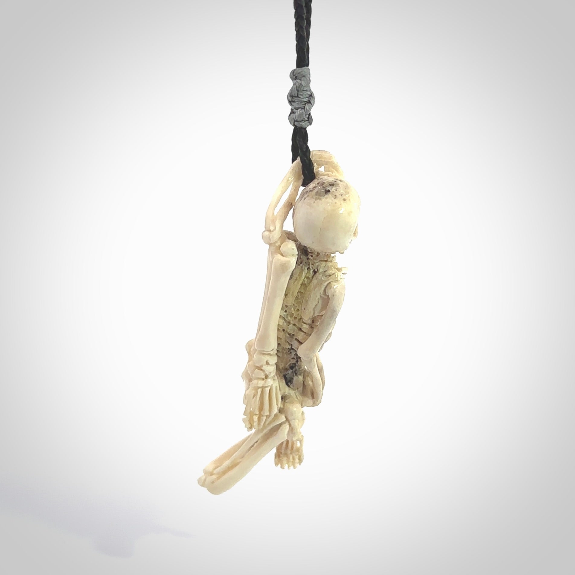 Hand carved deer antler, bone skeleton lying on its side pendant online for sale. Creative necklace for lovers of skeletons hand made from deer antler, bone. Free shipping worldwide. We provide this pendant with an adjustable cord.