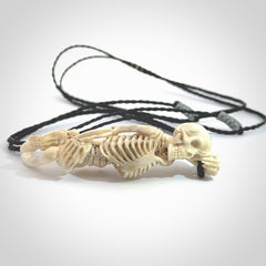 Hand carved deer antler, bone skeleton lying on its side pendant online for sale. Creative necklace for lovers of skeletons hand made from deer antler, bone. Free shipping worldwide. We provide this pendant with an adjustable cord.