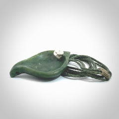 This picture shows a hand carved drop pendant made from a deep green coloured New Zealand Pounamu, jade. The front face is a concave, cupped design and the back is round. It is provided with an adjustable fern green cord in a woven kete pouch. Shipped to you with Express Courier.