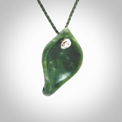 This picture shows a hand carved drop pendant made from a deep green coloured New Zealand Pounamu, jade. The front face is a concave, cupped design and the back is round. It is provided with an adjustable fern green cord in a woven kete pouch. Shipped to you with Express Courier.