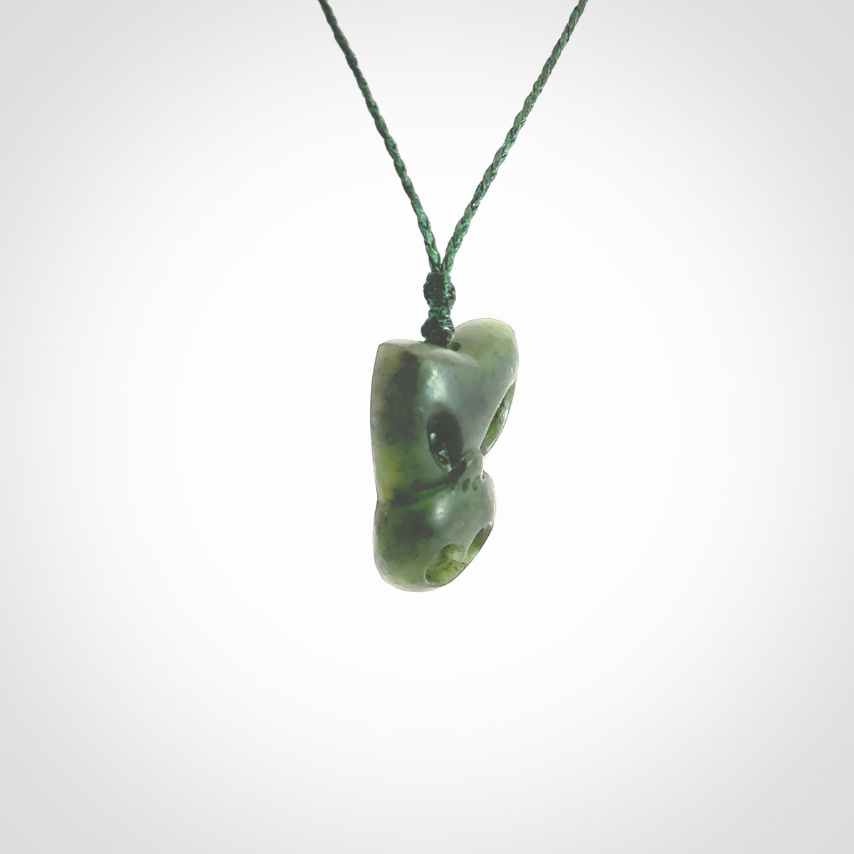 Hand carved New Zealand Jade Pounamu Wheku face pendant. Carved from New Zealand Jade by NZ Pacific. Hand crafted Jade jewellery for sale online. Pacific carving pendant, striking and unique delivered to you with Express Courier at no extra cost.