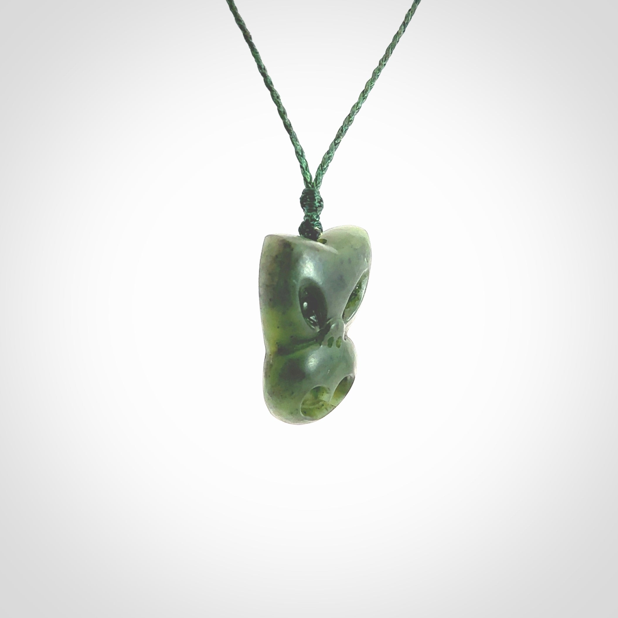 Hand carved New Zealand Jade Pounamu Wheku face pendant. Carved from New Zealand Jade by NZ Pacific. Hand crafted Jade jewellery for sale online. Pacific carving pendant, striking and unique delivered to you with Express Courier at no extra cost.