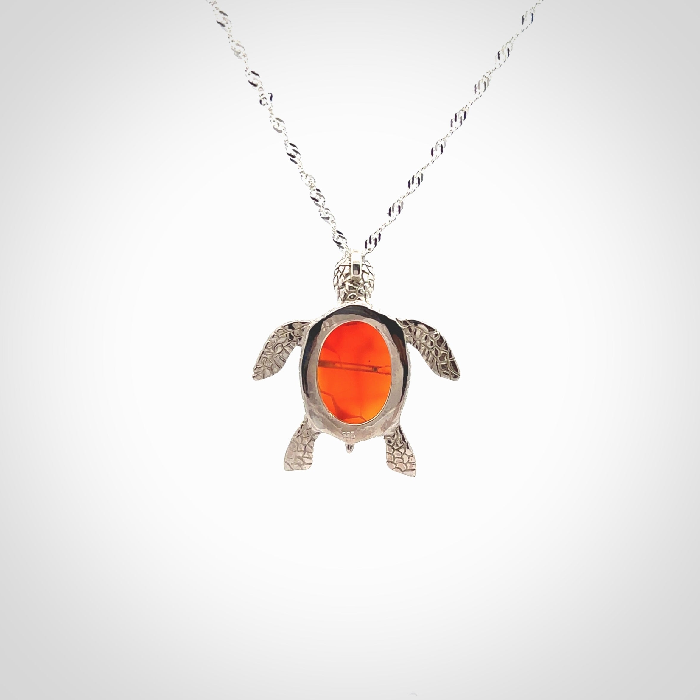 Fire Agate stone turtle in Sterling silver engraved casing. Hand carved jewellery made by NZ Pacific and for sale online. Moana, Ocean, jewellery hand carved in fire agate and Sterling Silver turtle necklace.