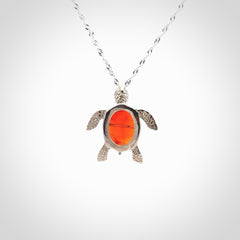 Fire Agate stone turtle in Sterling silver engraved casing. Hand carved jewellery made by NZ Pacific and for sale online. Moana, Ocean, jewellery hand carved in fire agate and Sterling Silver turtle necklace.