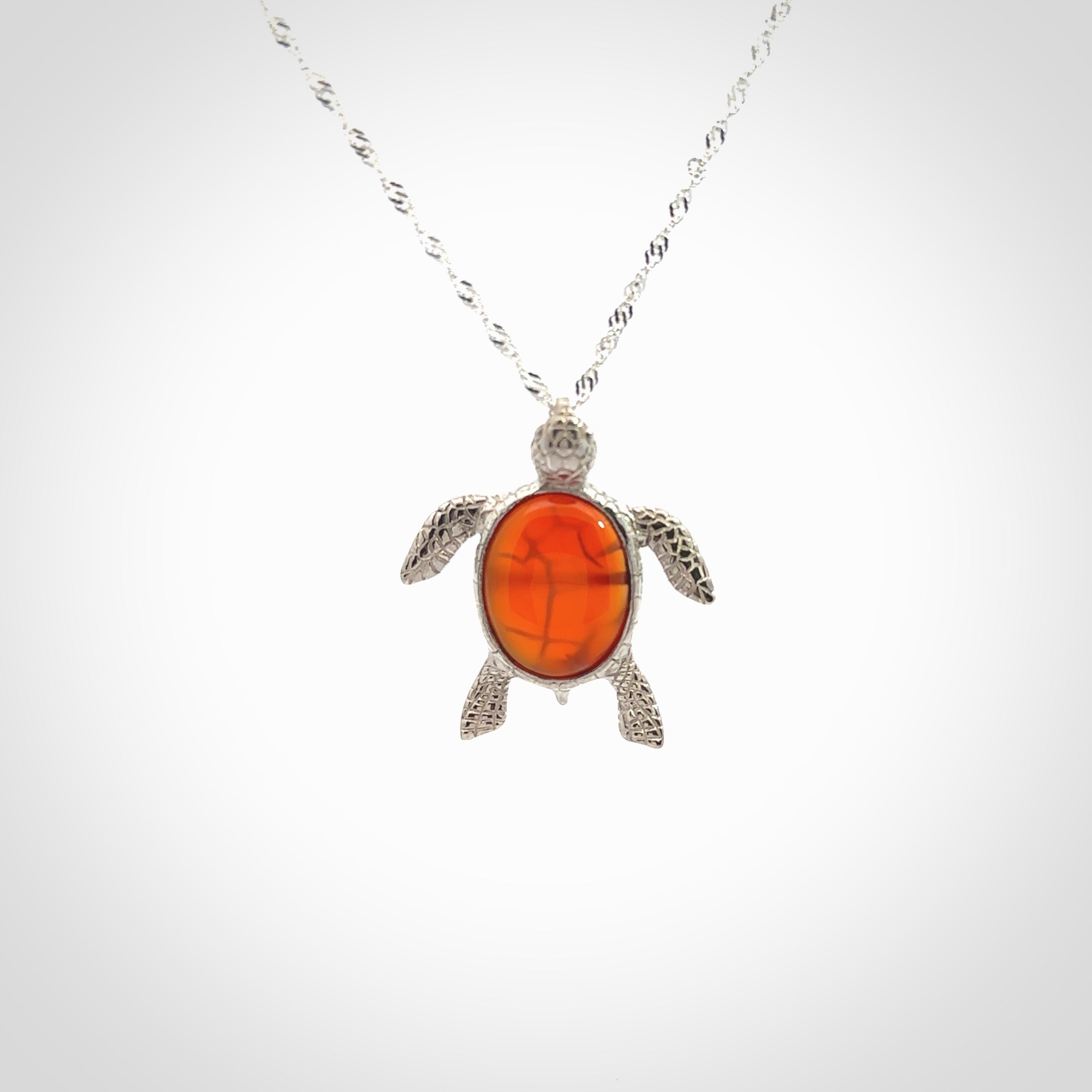 Fire Agate stone turtle in Sterling silver engraved casing. Hand carved jewellery made by NZ Pacific and for sale online. Moana, Ocean, jewellery hand carved in fire agate and Sterling Silver turtle necklace.