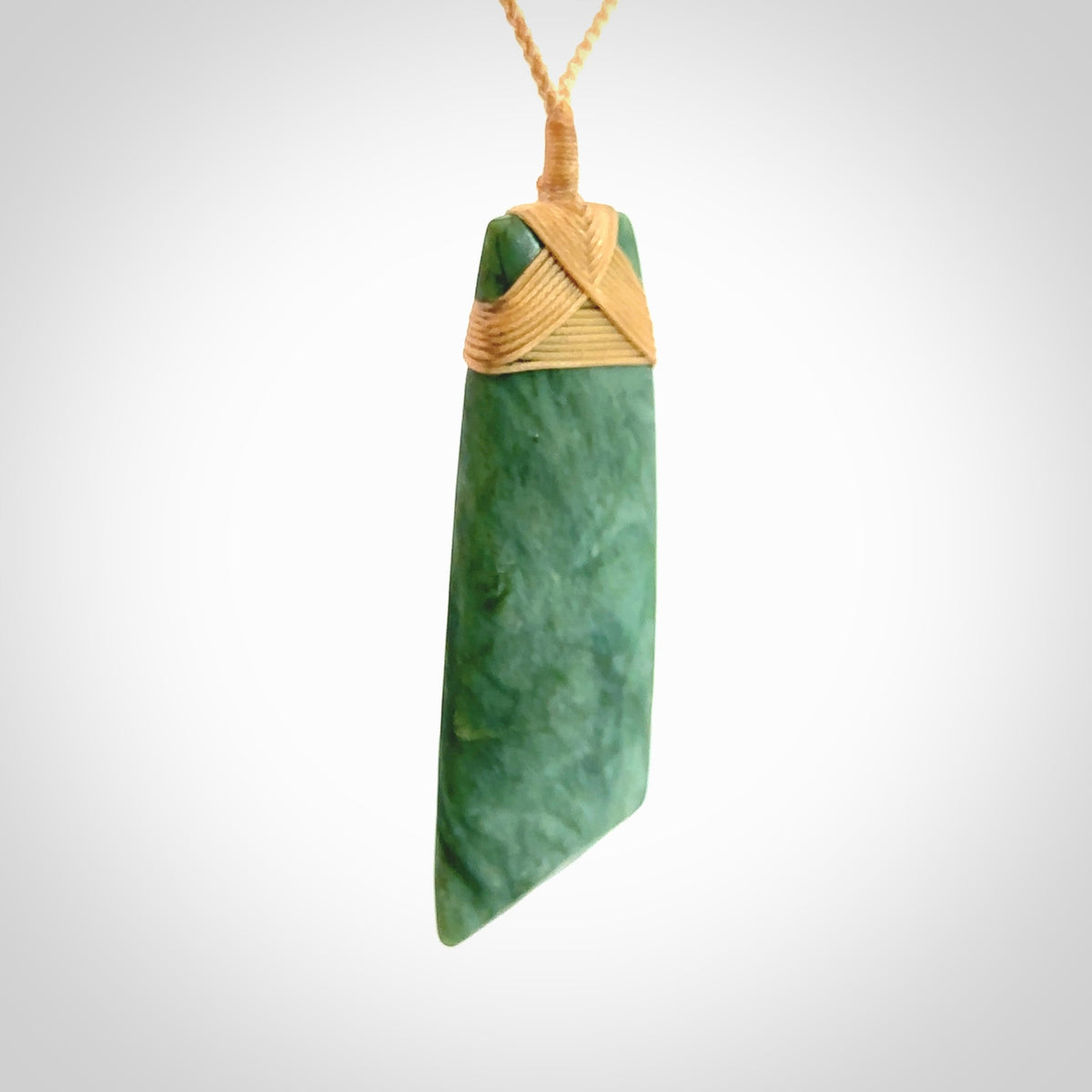 Hand carved from a lovely piece of local New Zealand Jade. The quality of the workmanship and design is outstanding - this is a piece you will want to wear all the time. We have suspended this from a 4-plait beige cord which can be adjusted with a couple of slip knots and beige binding. Hand made by Kyohei Noguchi.