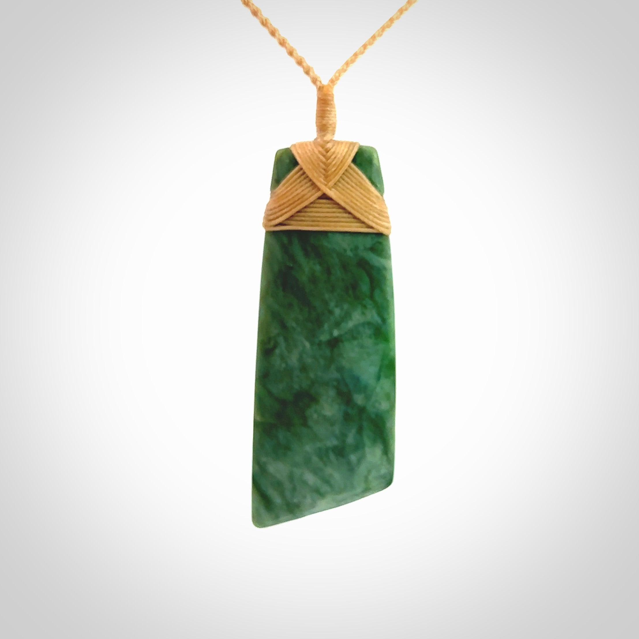 Hand carved from a lovely piece of local New Zealand Jade. The quality of the workmanship and design is outstanding - this is a piece you will want to wear all the time. We have suspended this from a 4-plait beige cord which can be adjusted with a couple of slip knots and beige binding. Hand made by Kyohei Noguchi.