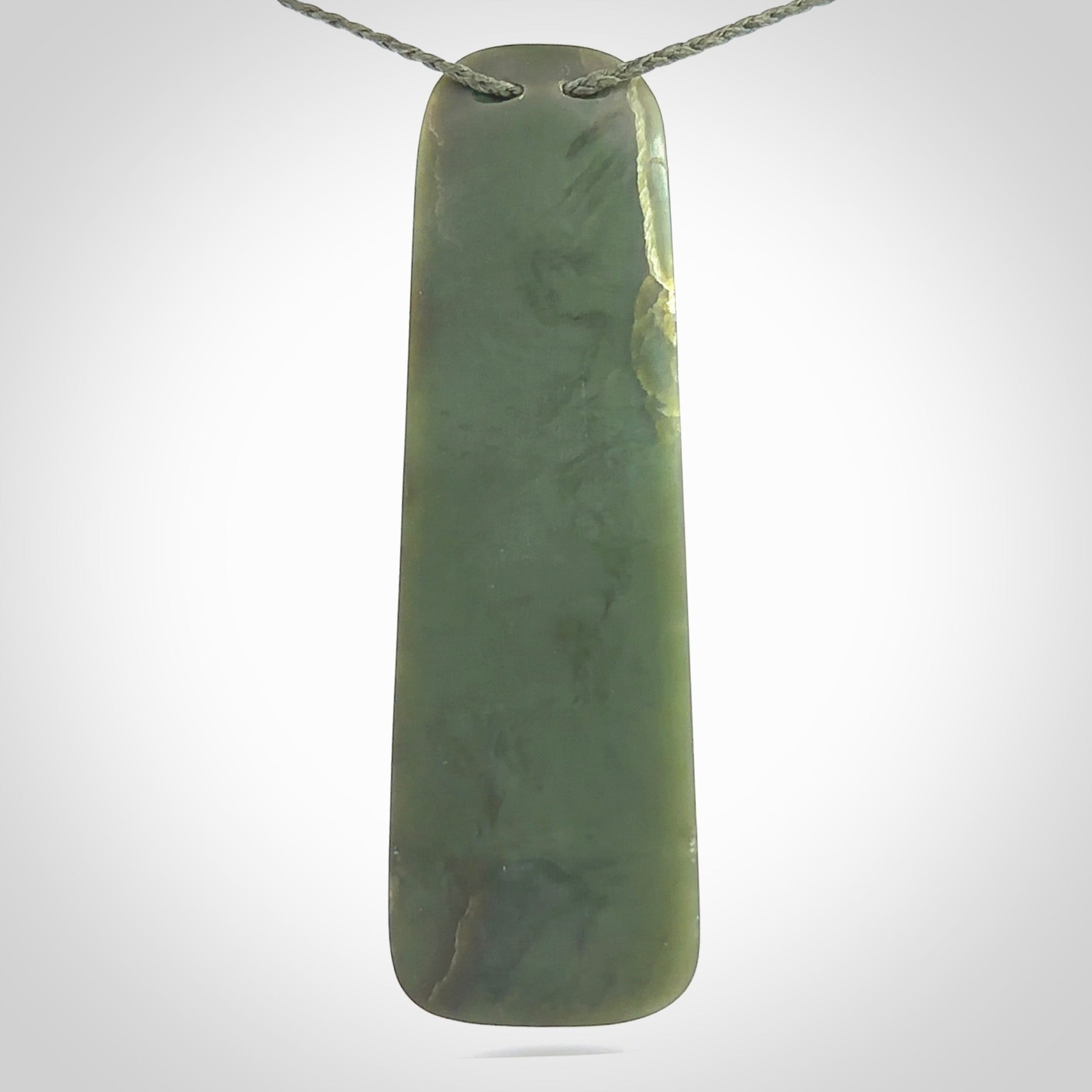 This photo shows a large jade drop shaped pendant. It a a lovely, colourful Inanga jade. The cord is a green colour and is adjustable in length. One only large, contemporary drop necklace from Jade, by Rueben Tipene.