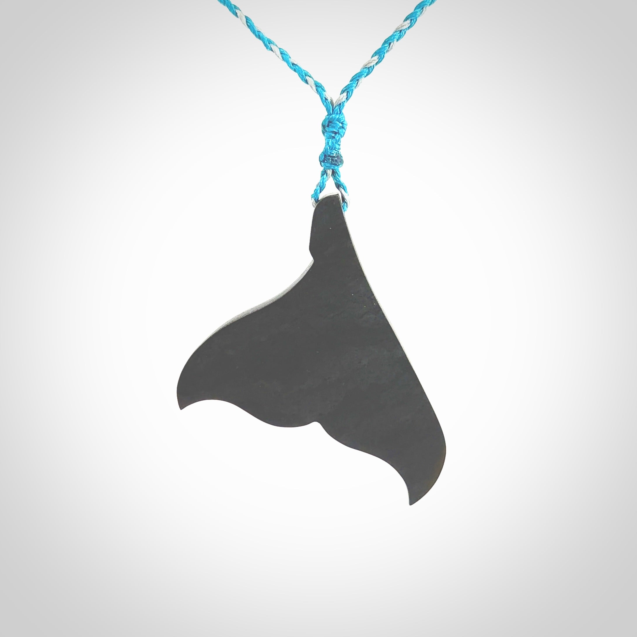 Hand carved New Zealand Argillite Stone whale tail pendant by Rueben Tipene. Hand made art to wear for lovers of the ocean. Delivered with express courier and delivered to you on an adjustable cord.