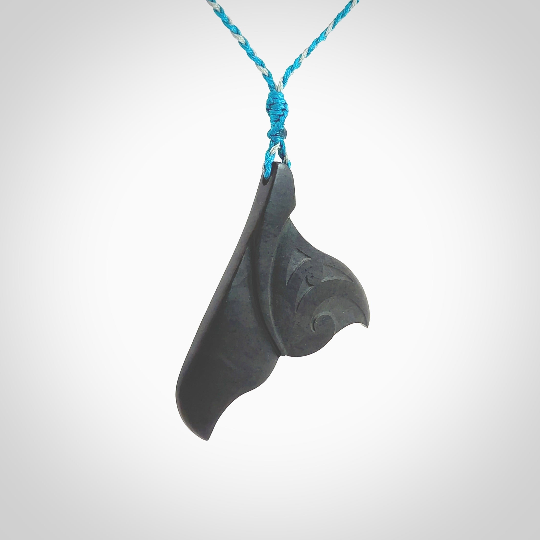 Hand carved New Zealand Argillite Stone whale tail pendant by Rueben Tipene. Hand made art to wear for lovers of the ocean. Delivered with express courier and delivered to you on an adjustable cord.