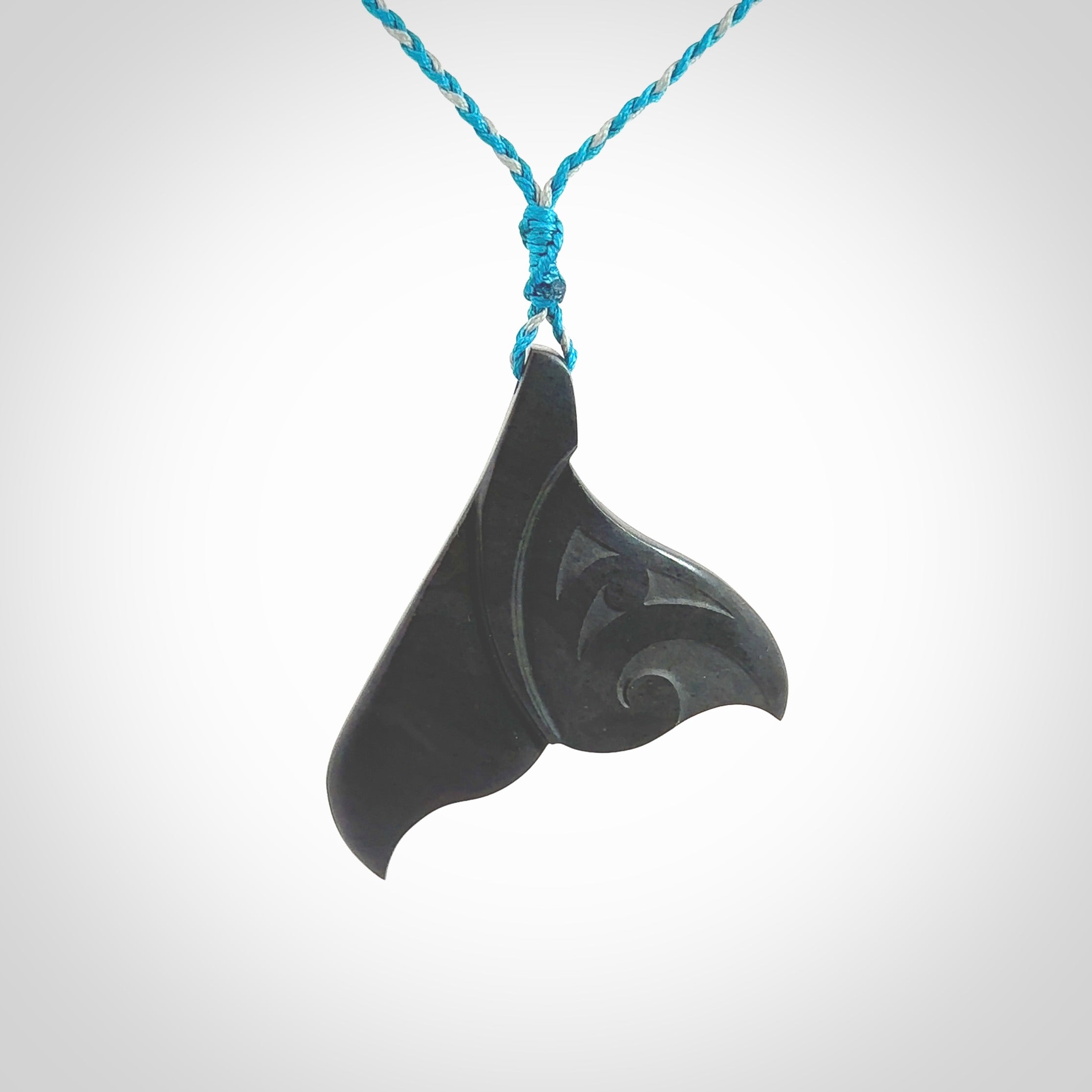 Hand carved New Zealand Argillite Stone whale tail pendant by Rueben Tipene. Hand made art to wear for lovers of the ocean. Delivered with express courier and delivered to you on an adjustable cord.