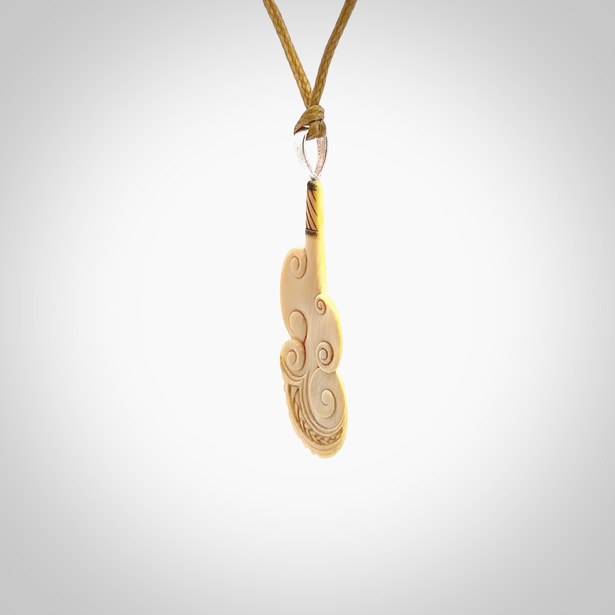 Hand carved engraved woolly mammoth tusk patu necklace hand made here in New Zealand. One only artistic patu pendant. Shipped to you with Express Courier. Stand out patu pendant for men and women. Mammoth tusk patu, art to wear.