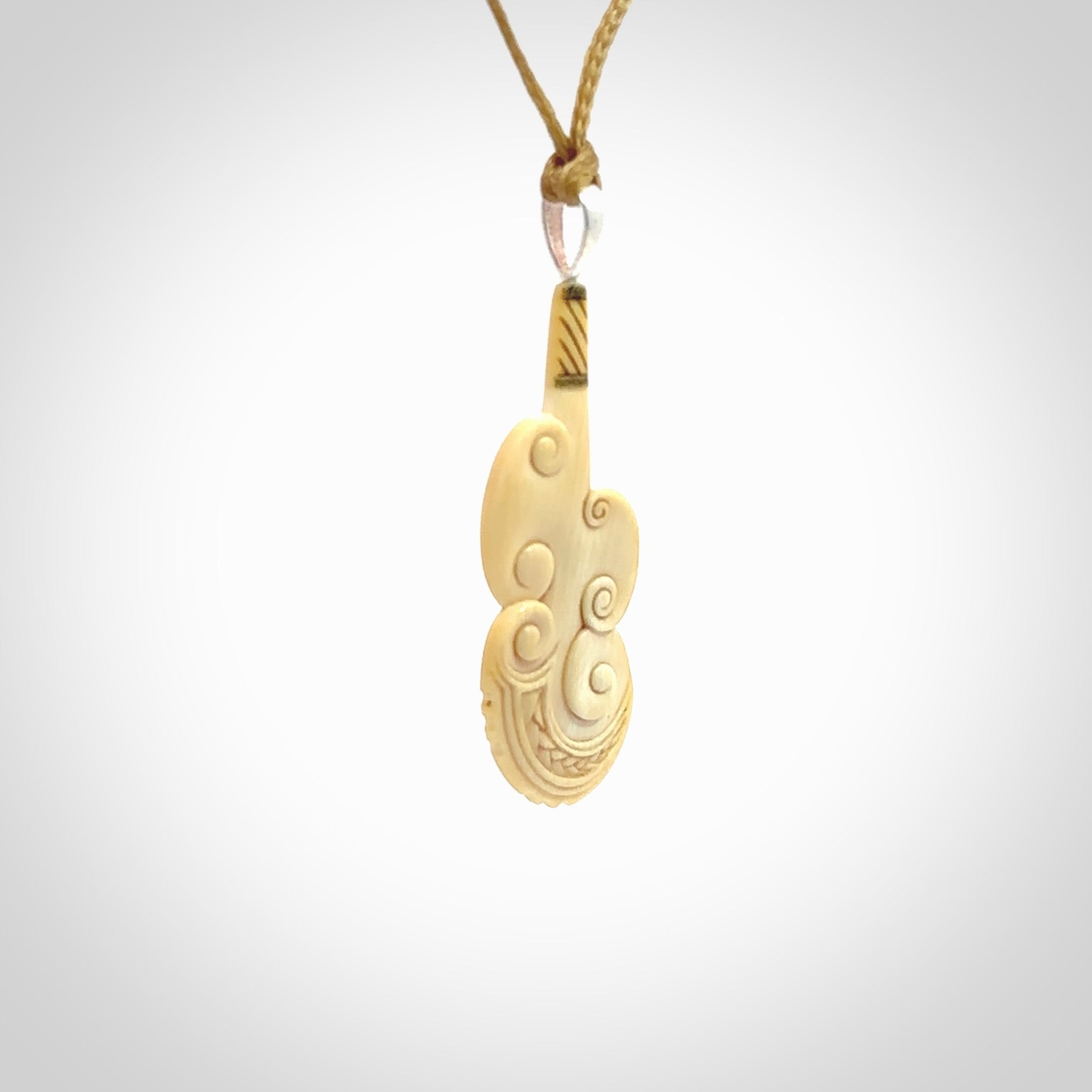 Hand carved engraved woolly mammoth tusk patu necklace hand made here in New Zealand. One only artistic patu pendant. Shipped to you with Express Courier. Stand out patu pendant for men and women. Mammoth tusk patu, art to wear.