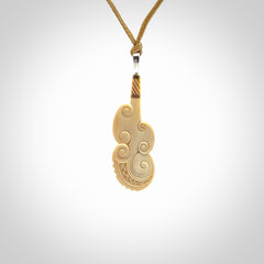 Hand carved engraved woolly mammoth tusk patu necklace hand made here in New Zealand. One only artistic patu pendant. Shipped to you with Express Courier. Stand out patu pendant for men and women. Mammoth tusk patu, art to wear.