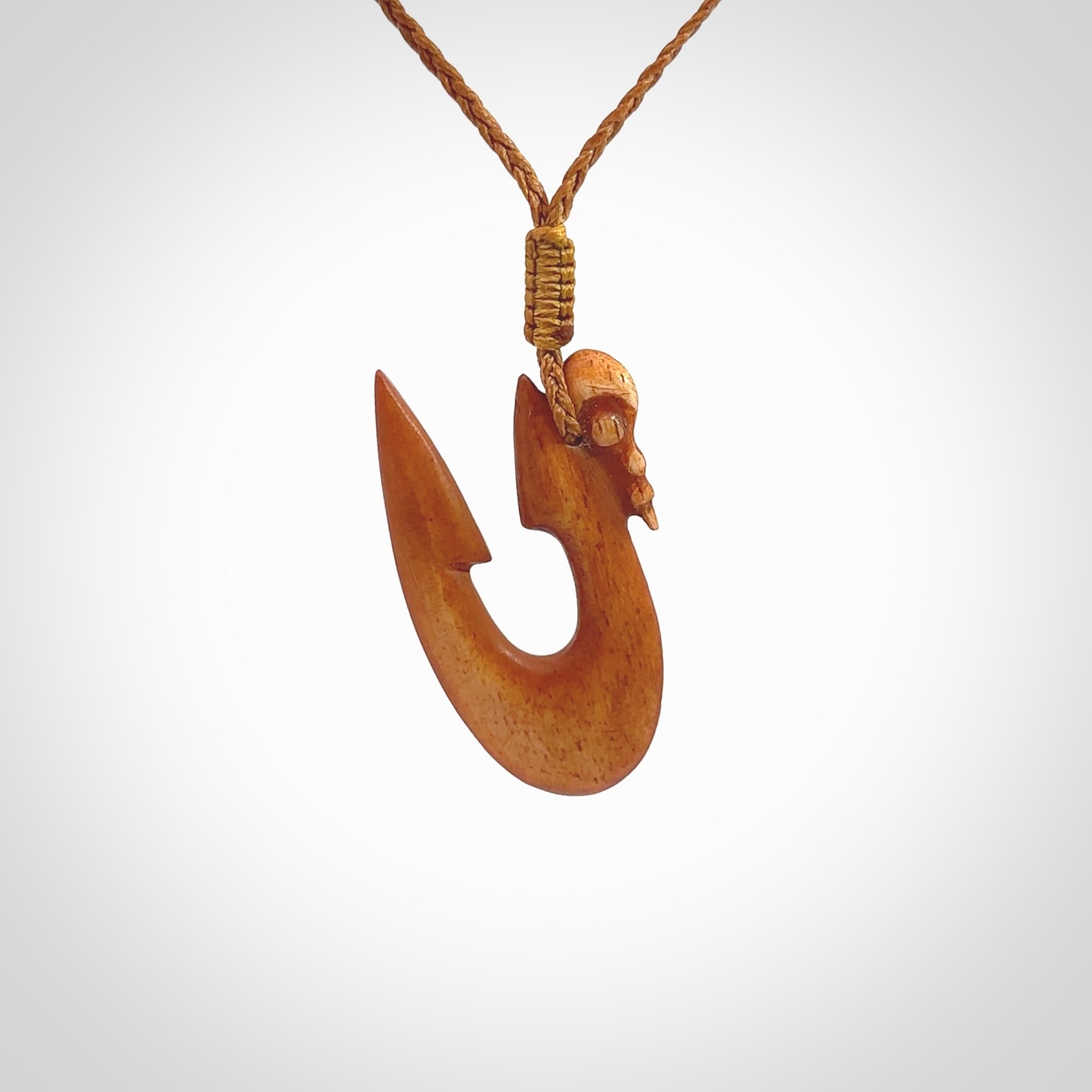 Natural stained cow bone manaia with hook pendant. Hand carved by Yuri Terenyi in New Zealand. Unique design pendant for sale online. One only stained bone manaia, hook necklace. Free delivery worldwide. Delivered with an adjustable cord.