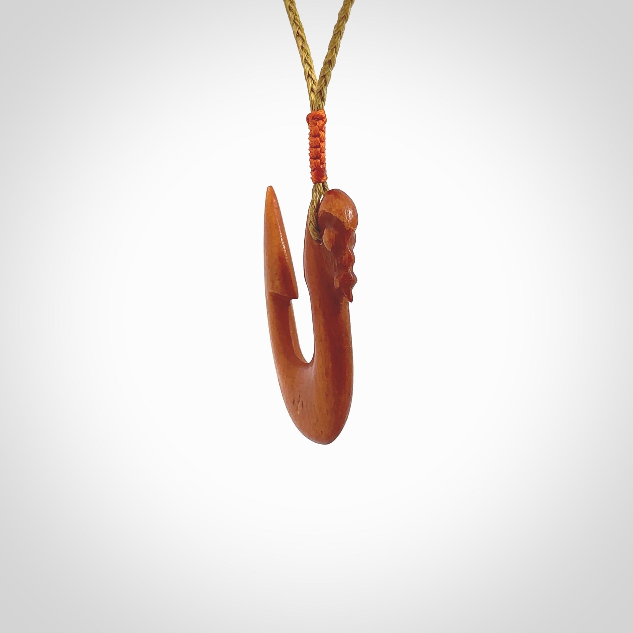 Natural stained cow bone manaia with hook pendant. Hand carved by Yuri Terenyi in New Zealand. Unique design pendant for sale online. One only stained bone manaia, hook necklace. Free delivery worldwide. Delivered with an adjustable cord.