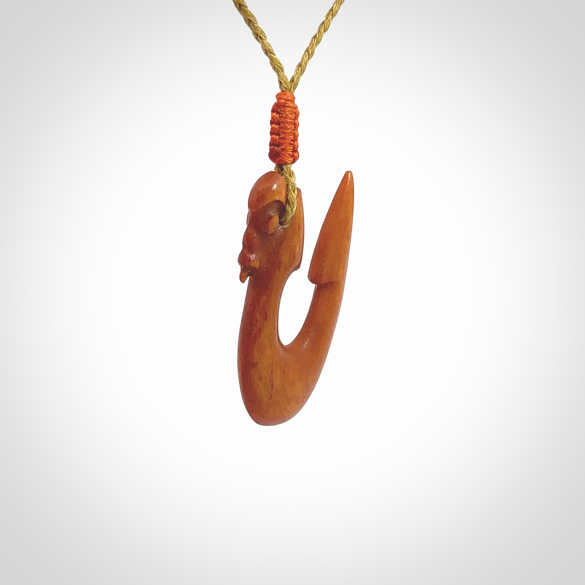 Natural stained cow bone manaia with hook pendant. Hand carved by Yuri Terenyi in New Zealand. Unique design pendant for sale online. One only stained bone manaia, hook necklace. Free delivery worldwide. Delivered with an adjustable cord.