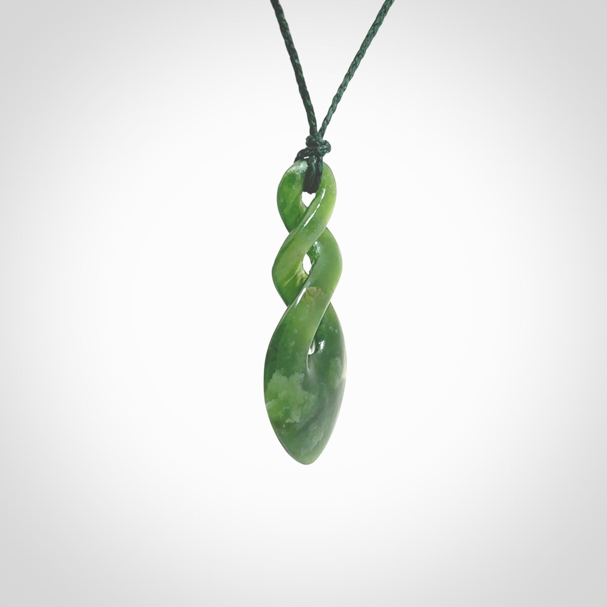 Hand carved New Zealand jade twist pendant. Carved in New Zealand by NZ Pacific. Unique double twist jewellery for sale online. Provided with an adjustable Manuka Green cord.