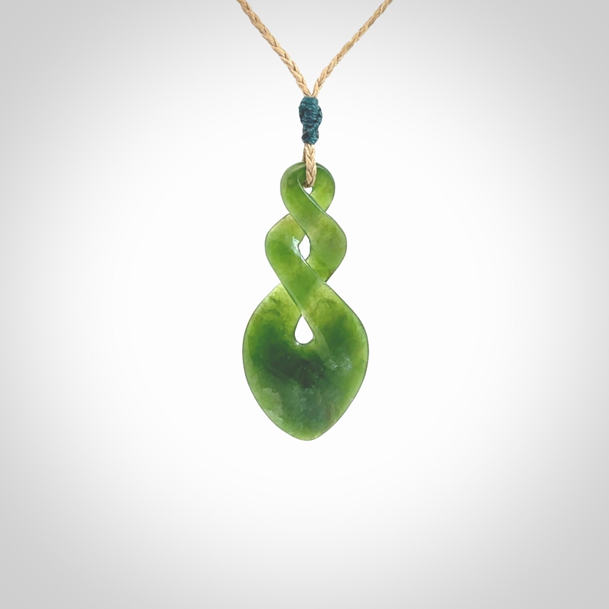 Hand carved New Zealand jade twist pendant. Carved in New Zealand by NZ Pacific. Unique double twist jewellery for sale online. Provided with an adjustable tan cord.