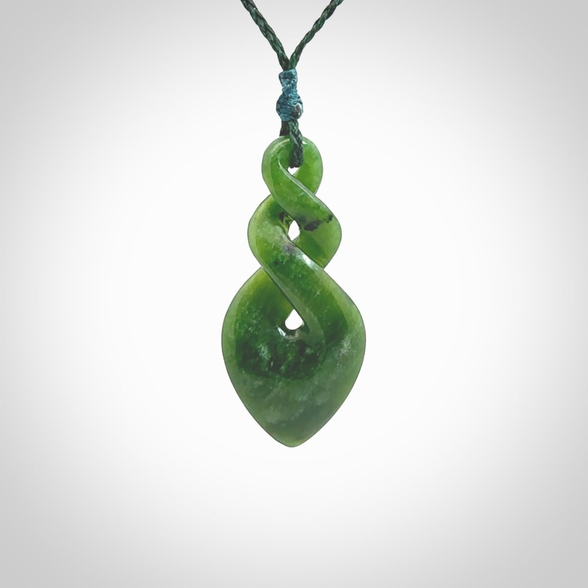 Hand carved New Zealand jade twist pendant. Carved in New Zealand by NZ Pacific. Unique double twist jewellery for sale online. Provided with an adjustable Manuka Green cord.