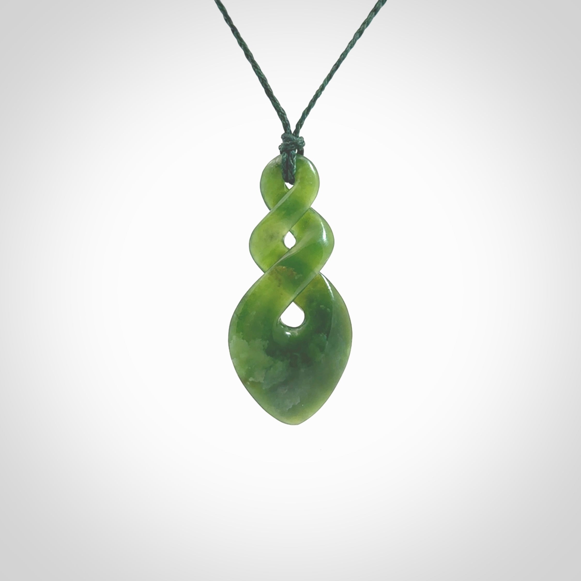 Hand carved New Zealand jade twist pendant. Carved in New Zealand by NZ Pacific. Unique double twist jewellery for sale online. Provided with an adjustable Manuka Green cord.