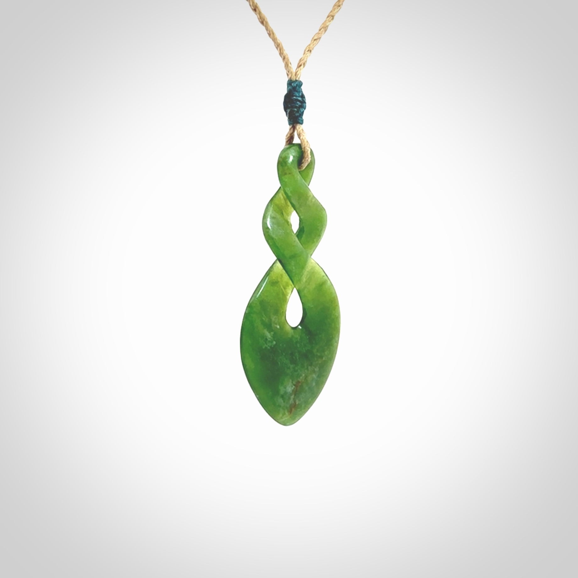 Hand carved New Zealand jade twist pendant. Carved in New Zealand by NZ Pacific. Unique double twist jewellery for sale online. Provided with an adjustable tan cord.