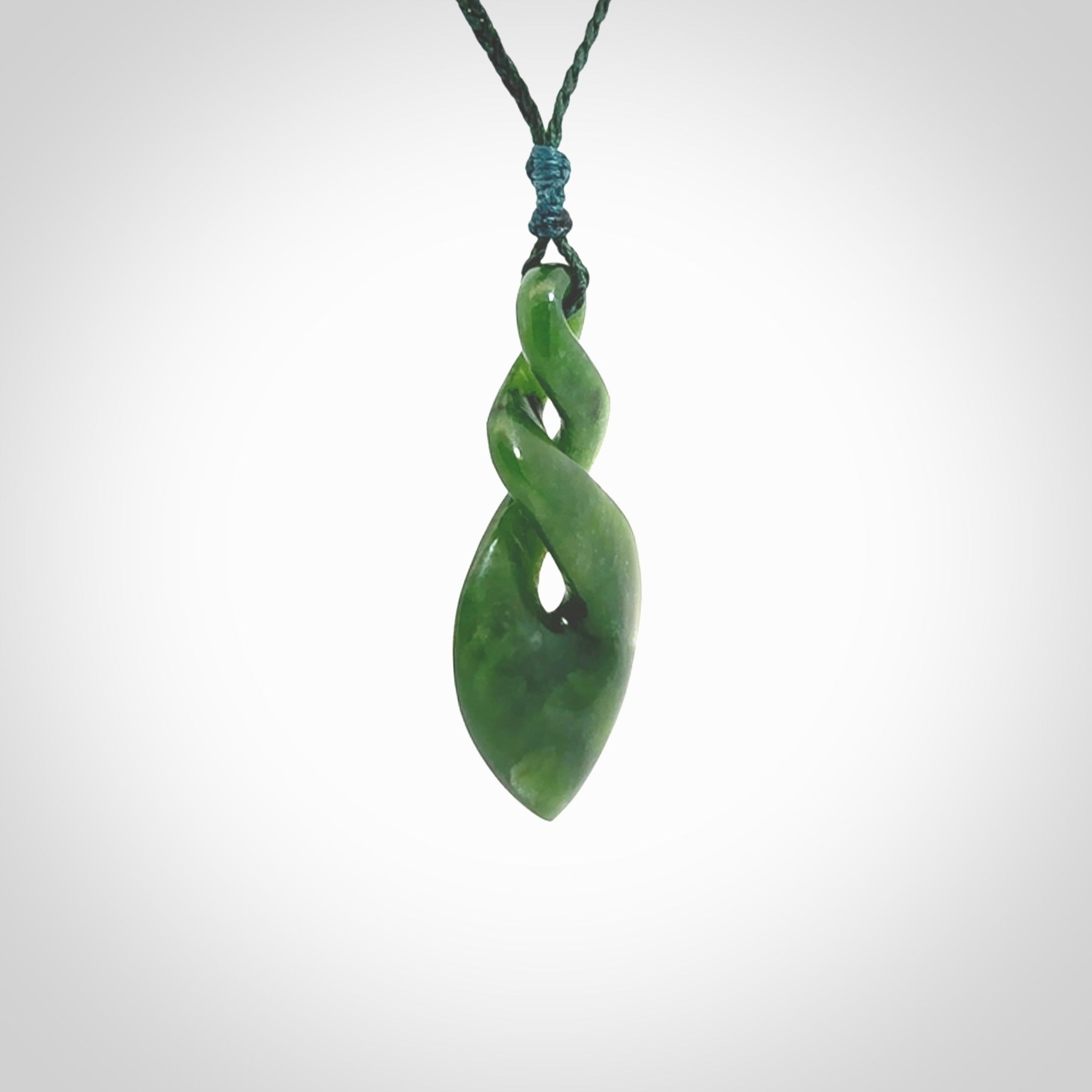 Hand carved New Zealand jade twist pendant. Carved in New Zealand by NZ Pacific. Unique double twist jewellery for sale online. Provided with an adjustable Manuka Green cord.