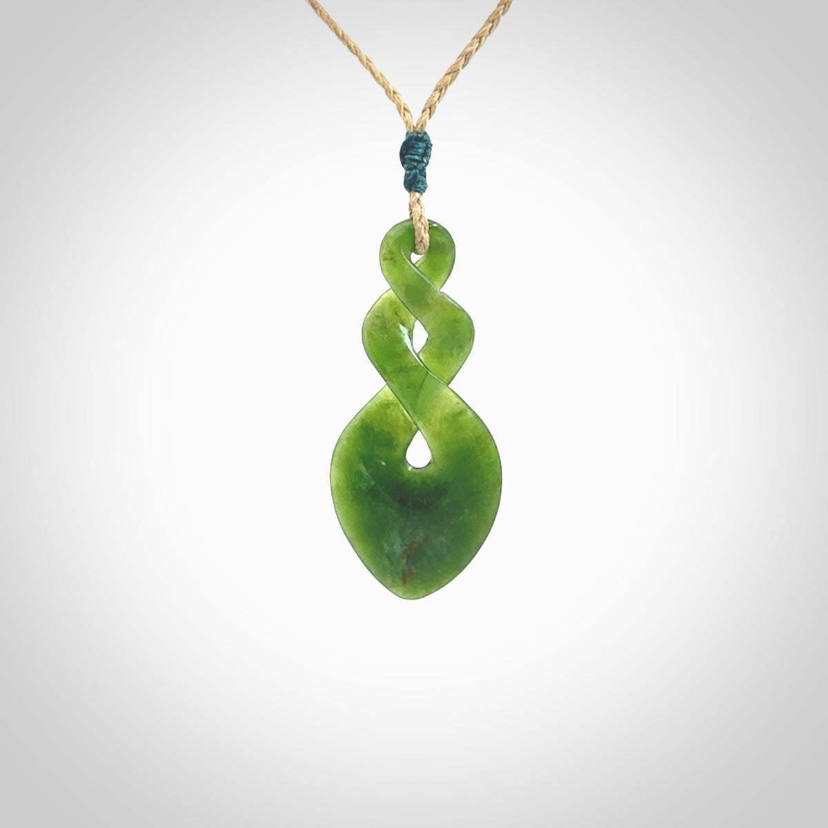 Hand carved New Zealand jade twist pendant. Carved in New Zealand by NZ Pacific. Unique double twist jewellery for sale online. Provided with an adjustable tan cord.