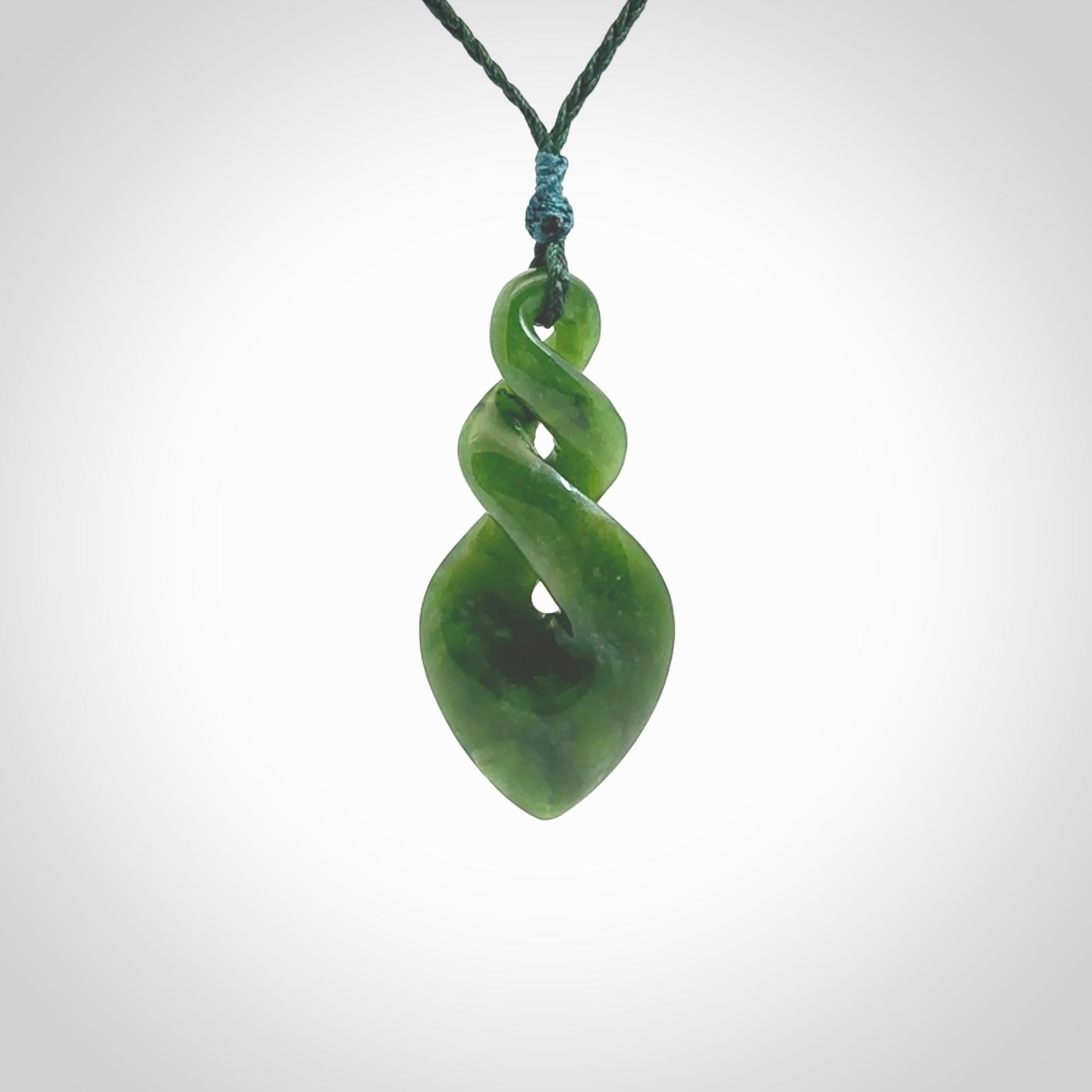 Hand carved New Zealand jade twist pendant. Carved in New Zealand by NZ Pacific. Unique double twist jewellery for sale online. Provided with an adjustable Manuka Green cord.