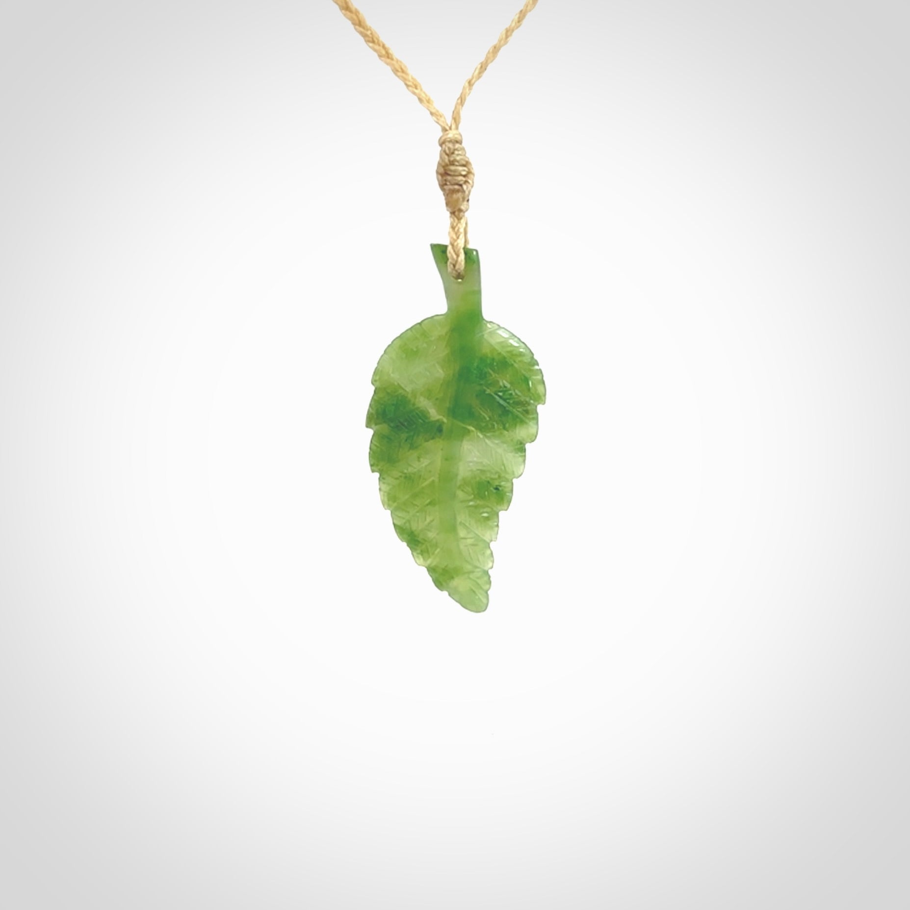 A delicate green jade fern leaf pendant with an adjustable neck cord. Green stone fern leaf necklace with adjustable cord. Delivery included.