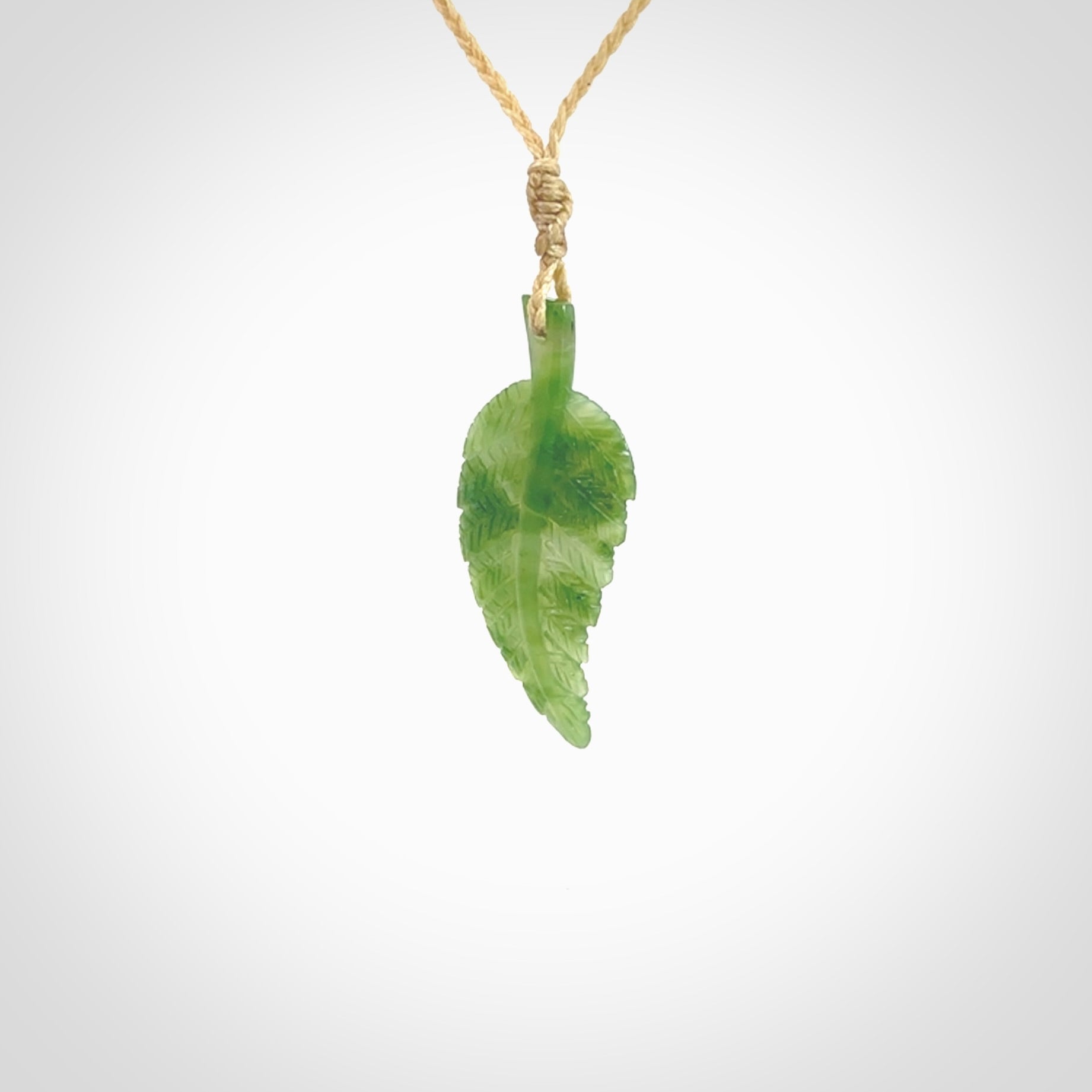 A delicate green jade fern leaf pendant with an adjustable neck cord. Green stone fern leaf necklace with adjustable cord. Delivery included.