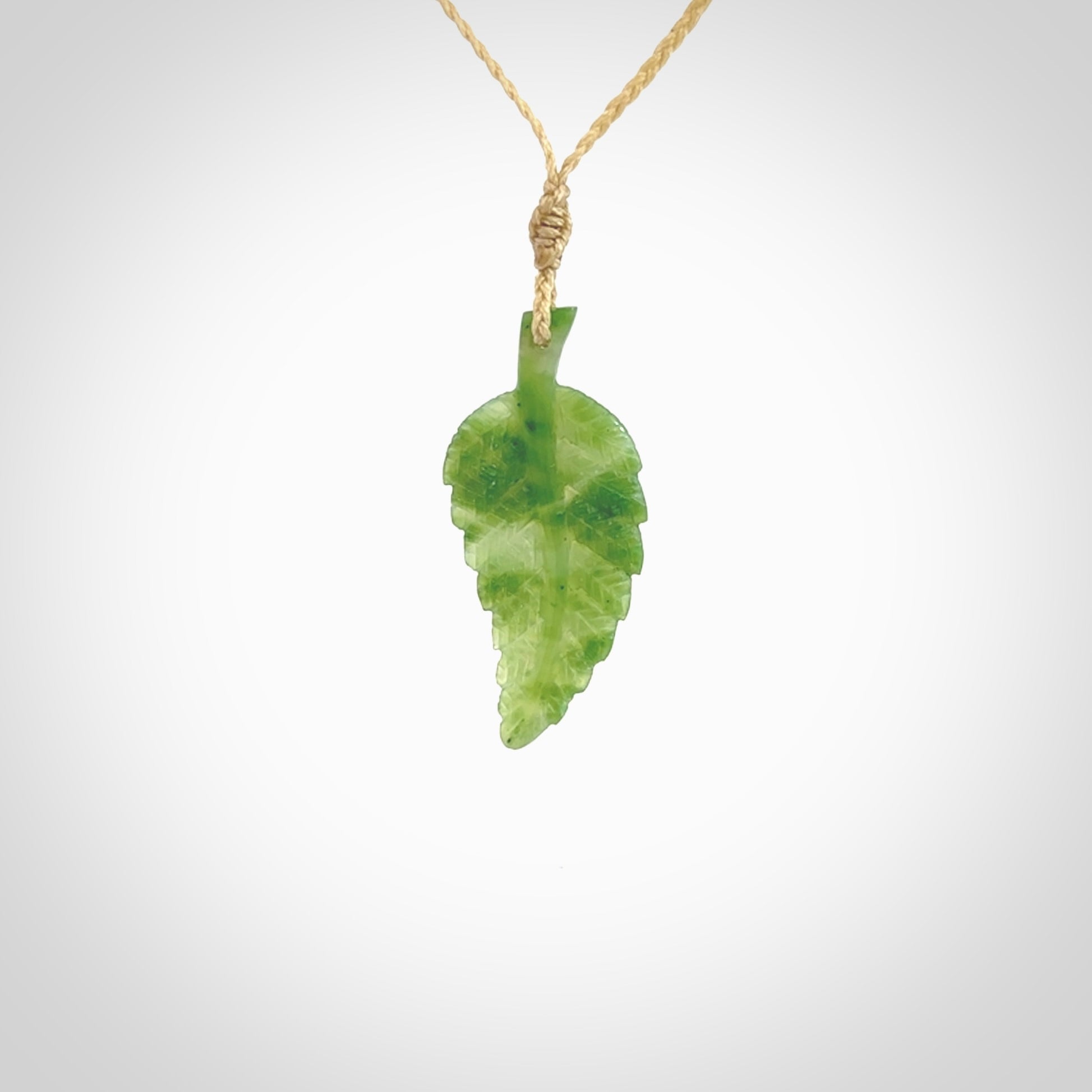 A delicate green jade fern leaf pendant with an adjustable neck cord. Green stone fern leaf necklace with adjustable cord. Delivery included.