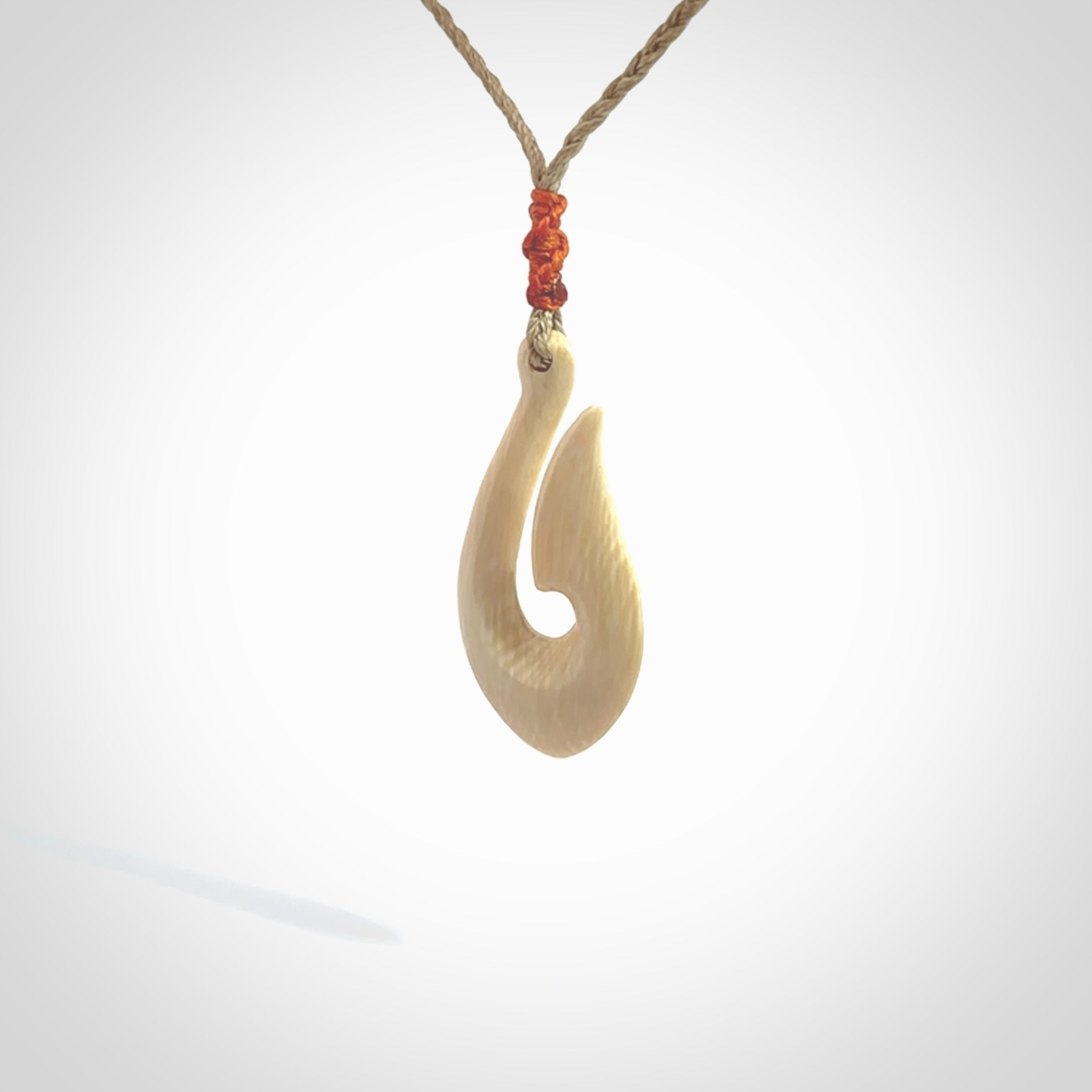 A fish hook necklace (hei-matau) hand-carved in a traditional style from Woolly Mammoth Tusk. These are glorious pieces of art to wear. Provided with adjustable cords and packaged in a woven kete pouch. Delivered with express courier.