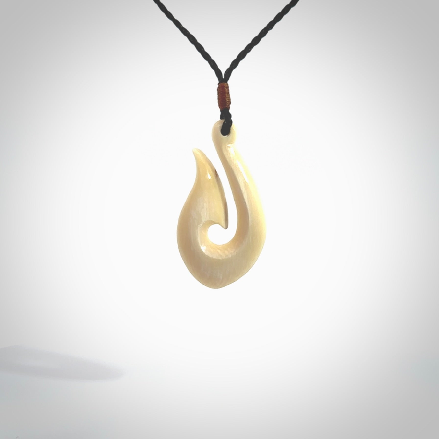 A fish hook necklace (hei-matau) hand-carved in a traditional style from Woolly Mammoth Tusk. These are glorious pieces of art to wear. Provided with adjustable cords and packaged in a woven kete pouch. Delivered with express courier.