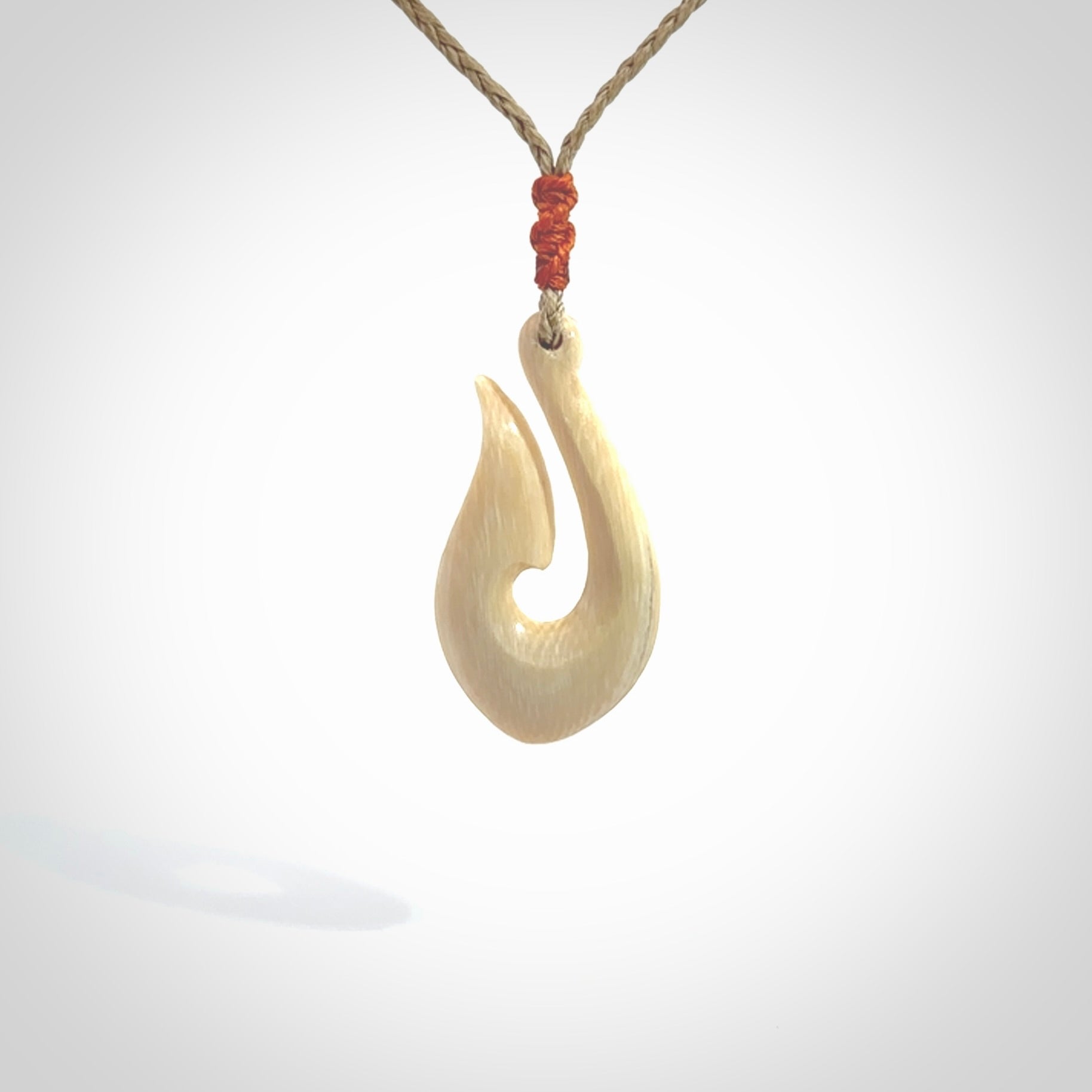 A fish hook necklace (hei-matau) hand-carved in a traditional style from Woolly Mammoth Tusk. These are glorious pieces of art to wear. Provided with adjustable cords and packaged in a woven kete pouch. Delivered with express courier.