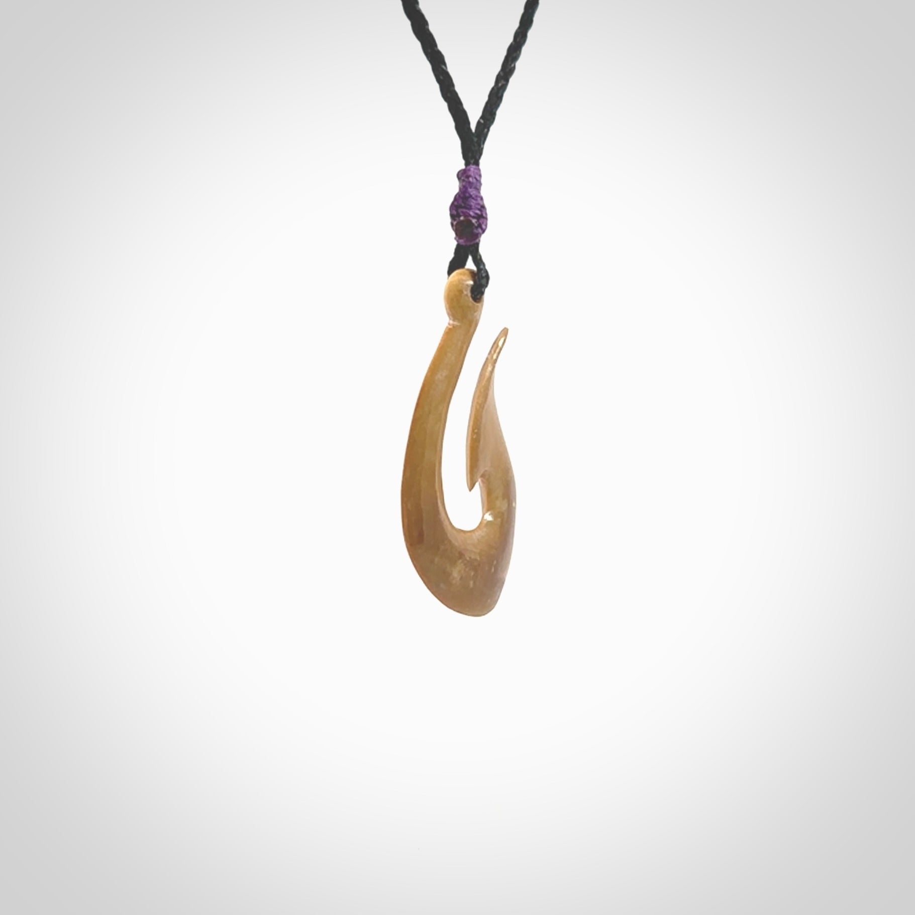 A fish hook necklace (hei-matau) hand-carved in a traditional style from Woolly Mammoth Tusk. These are glorious pieces of art to wear. Provided with adjustable cords and packaged in a woven kete pouch. Delivered with express courier.