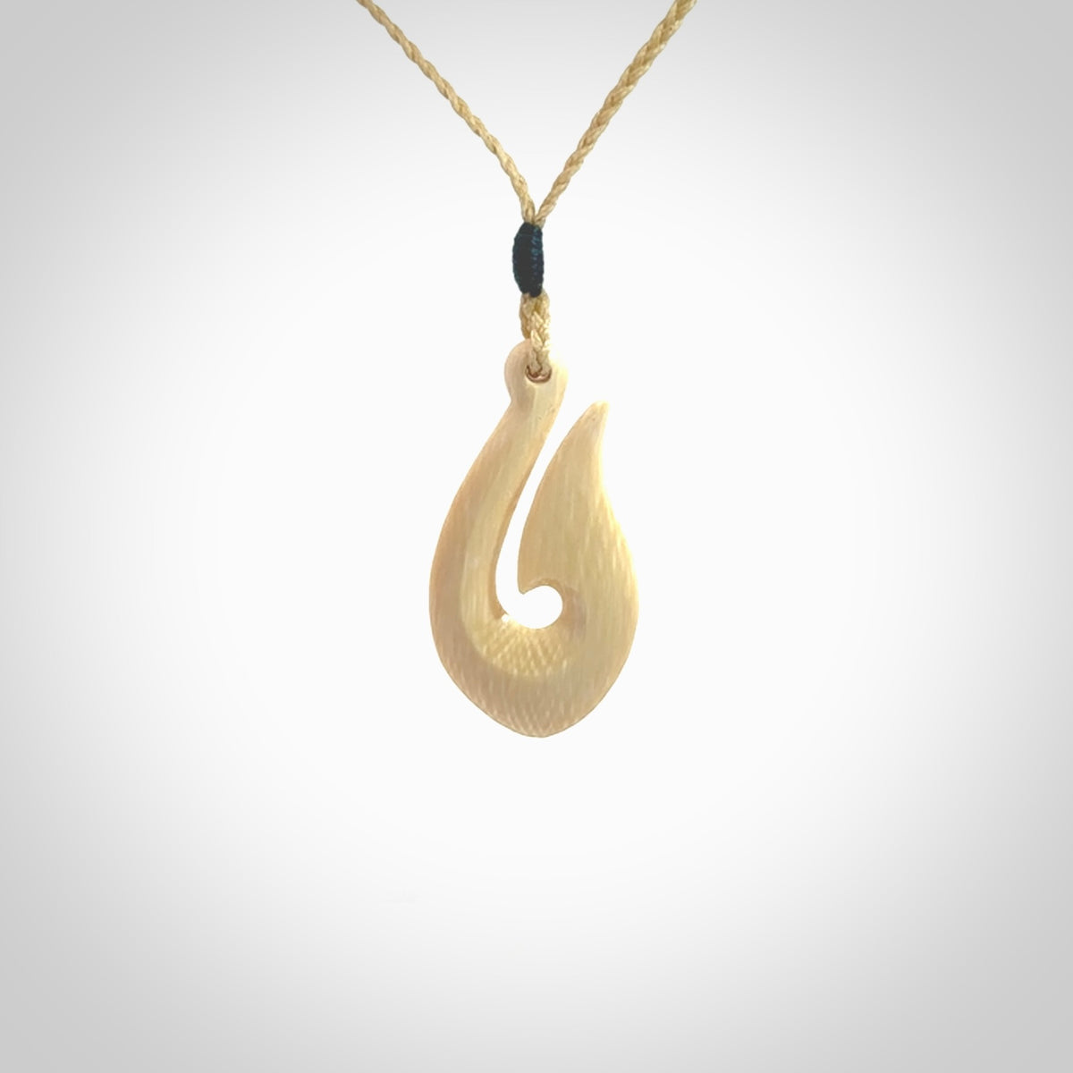 A fish hook necklace (hei-matau) hand-carved in a traditional style from Woolly Mammoth Tusk. These are glorious pieces of art to wear. Provided with adjustable cords and packaged in a woven kete pouch. Delivered with express courier.