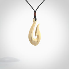 A fish hook necklace (hei-matau) hand-carved in a traditional style from Woolly Mammoth Tusk. These are glorious pieces of art to wear. Provided with adjustable cords and packaged in a woven kete pouch. Delivered with express courier.