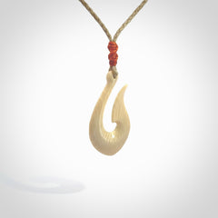 A fish hook necklace (hei-matau) hand-carved in a traditional style from Woolly Mammoth Tusk. These are glorious pieces of art to wear. Provided with adjustable cords and packaged in a woven kete pouch. Delivered with express courier.