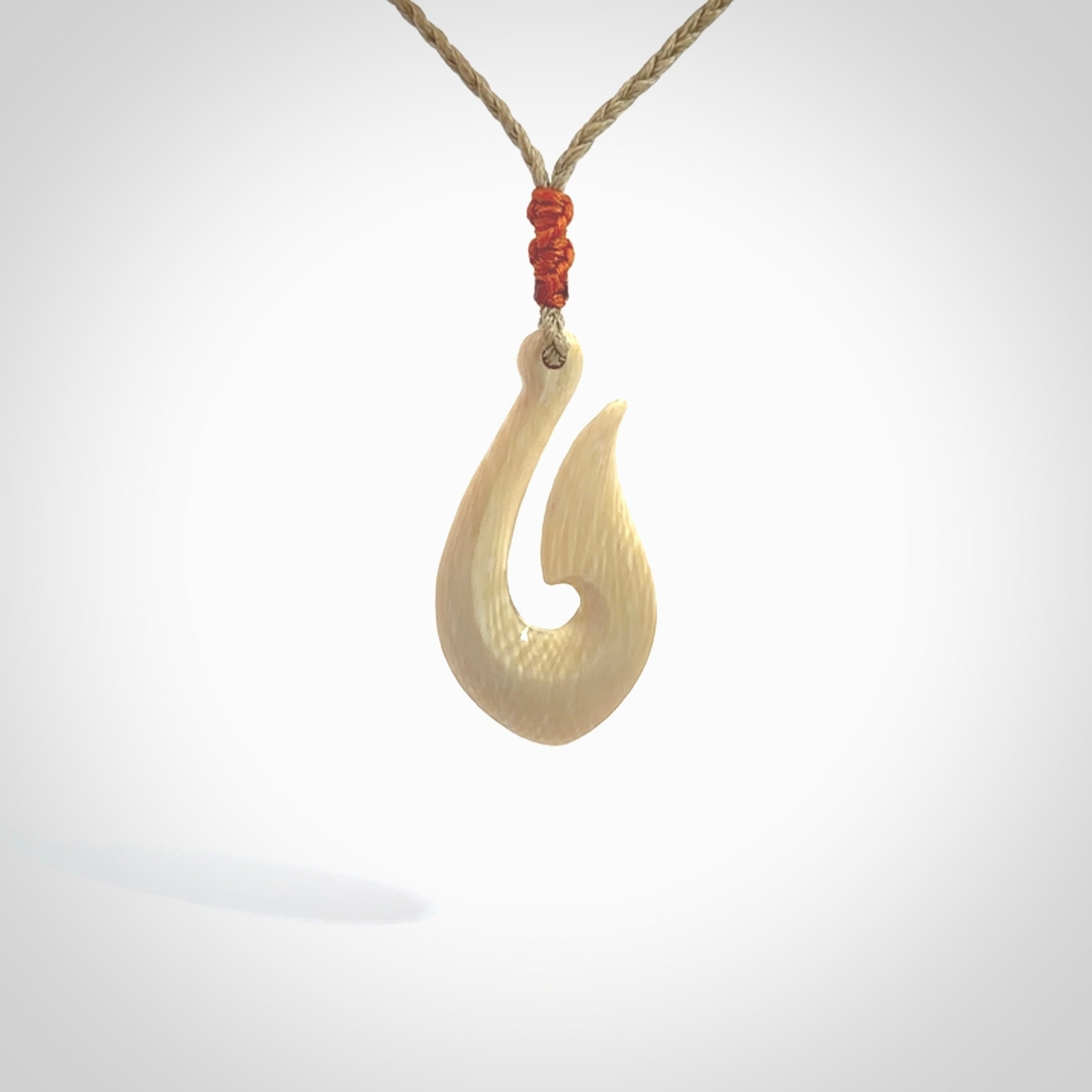 A fish hook necklace (hei-matau) hand-carved in a traditional style from Woolly Mammoth Tusk. These are glorious pieces of art to wear. Provided with adjustable cords and packaged in a woven kete pouch. Delivered with express courier.