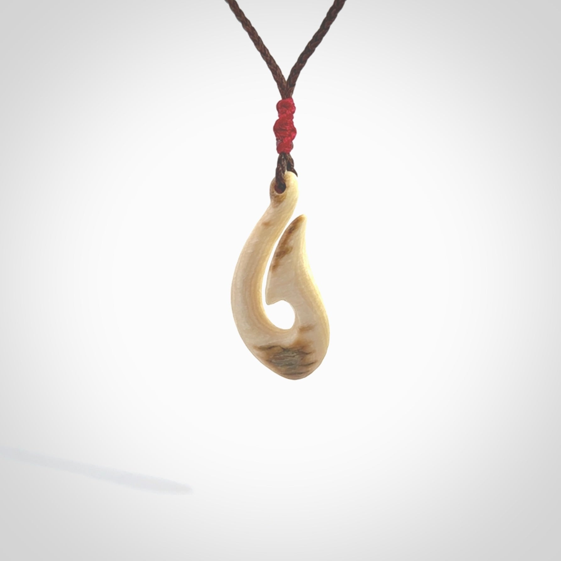 A fish hook necklace (hei-matau) hand-carved in a traditional style from Woolly Mammoth Tusk. These are glorious pieces of art to wear. Provided with adjustable cords and packaged in a woven kete pouch. Delivered with express courier.