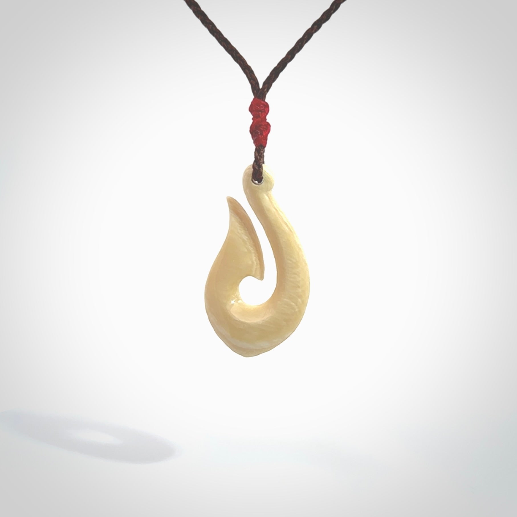 A fish hook necklace (hei-matau) hand-carved in a traditional style from Woolly Mammoth Tusk. These are glorious pieces of art to wear. Provided with adjustable cords and packaged in a woven kete pouch. Delivered with express courier.