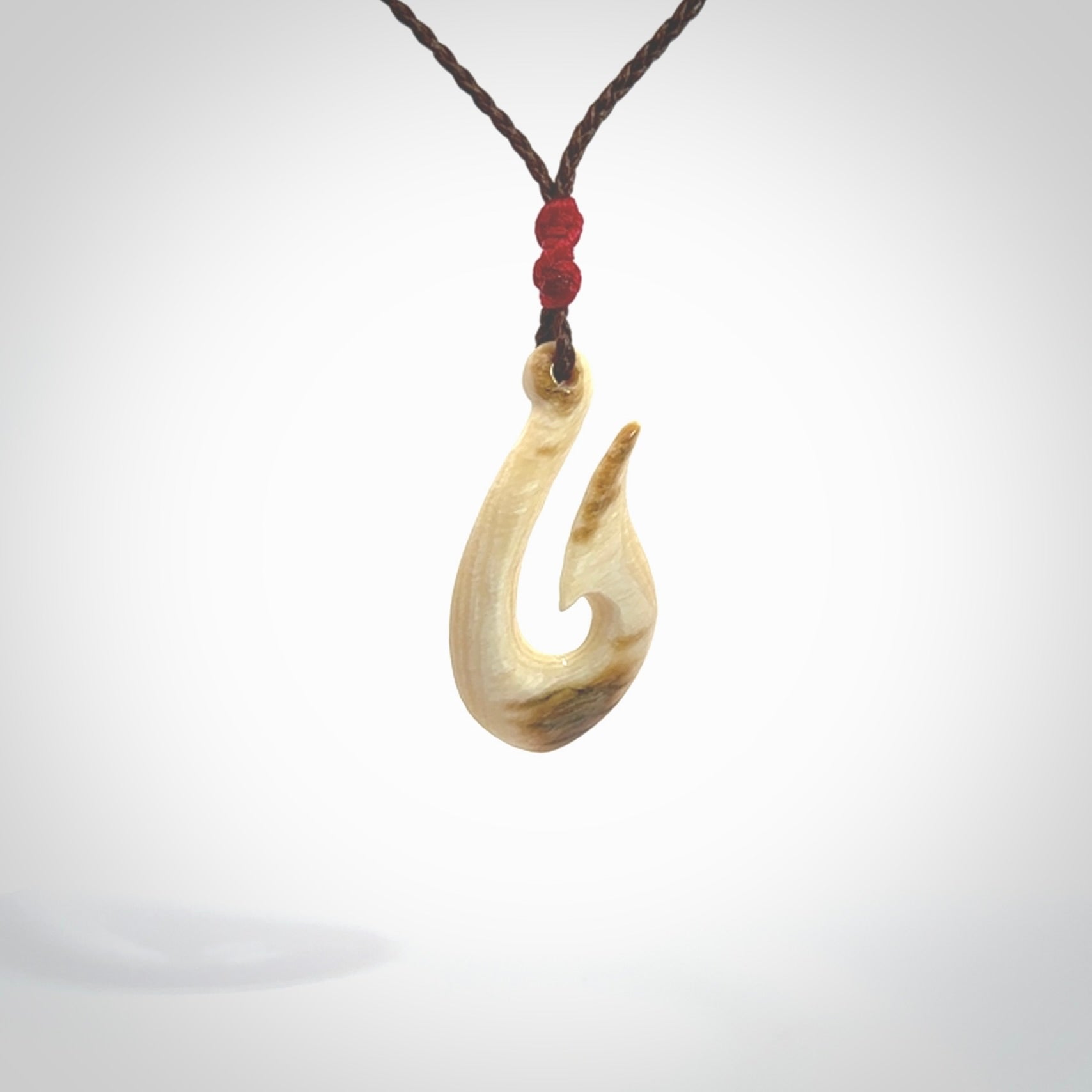 A fish hook necklace (hei-matau) hand-carved in a traditional style from Woolly Mammoth Tusk. These are glorious pieces of art to wear. Provided with adjustable cords and packaged in a woven kete pouch. Delivered with express courier.