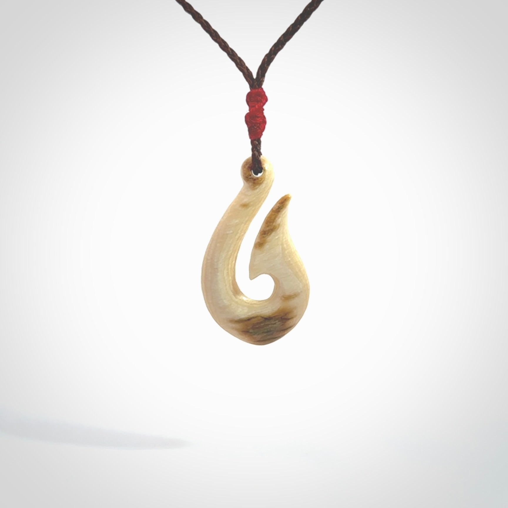 A fish hook necklace (hei-matau) hand-carved in a traditional style from Woolly Mammoth Tusk. These are glorious pieces of art to wear. Provided with adjustable cords and packaged in a woven kete pouch. Delivered with express courier.