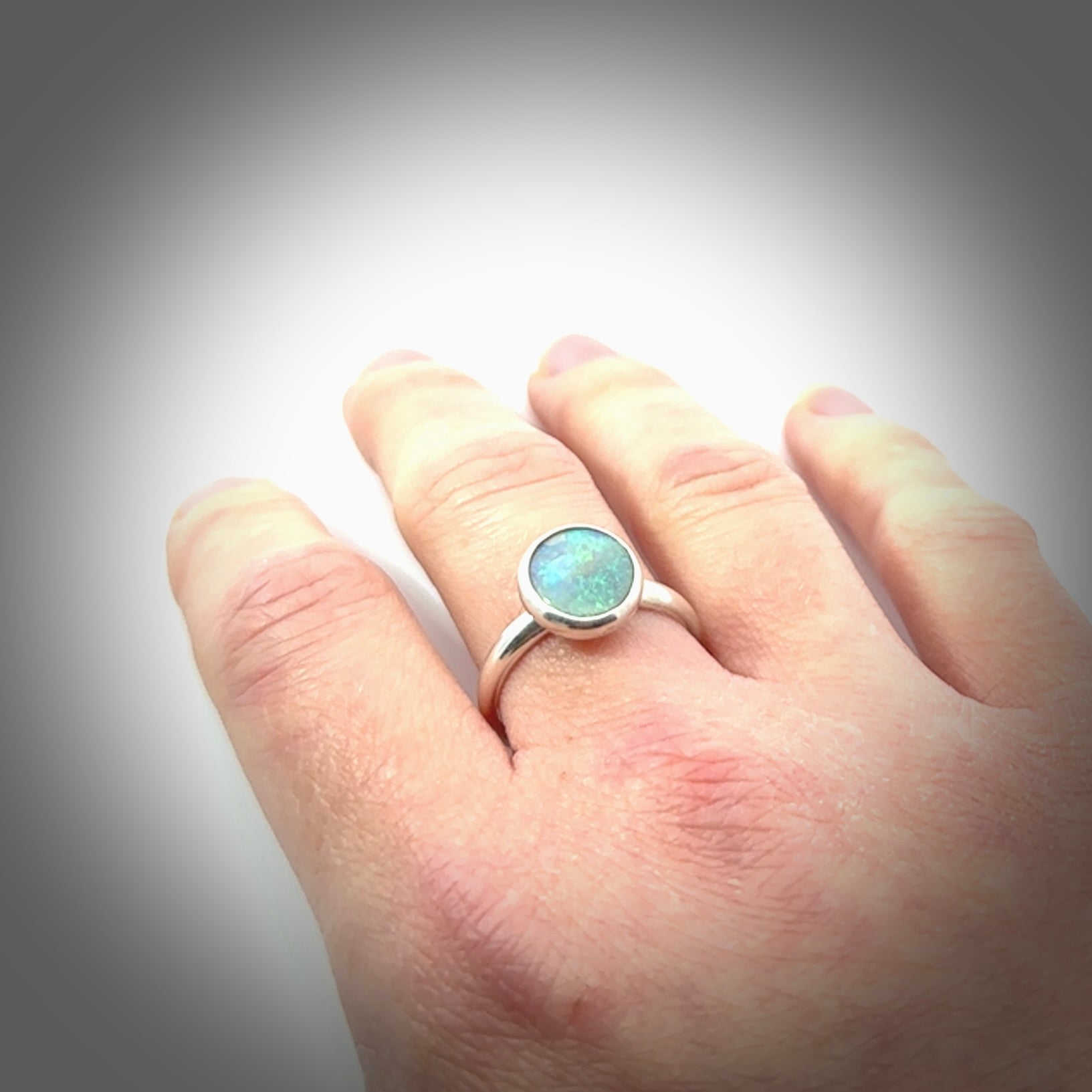 This is a handcrafted real opal ring with sterling silver. The colours are a gorgeous turquoise blue. This is a solid little work of art. We ship this worldwide for free and are happy to answer any questions that you may have about these or other products on our website.